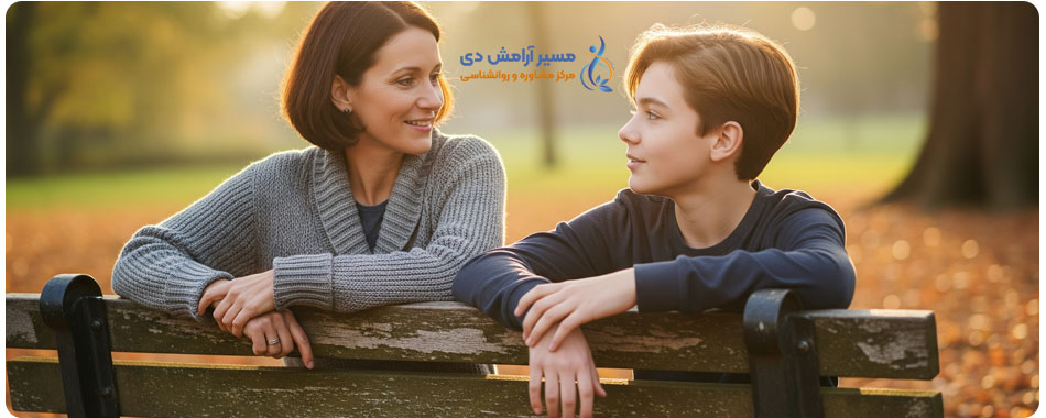 یک عکس واقعی از والد و نوجوان که در یک پارک پاییزی روی نیمکت نشسته‌اند و با احترام و علاقه متقابل با هم صحبت می‌کنند.

